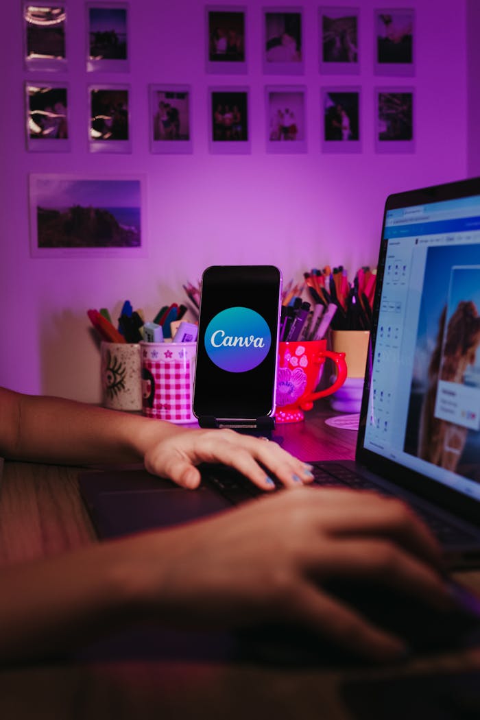 Mastering the First Impression: Your intriguing post title goes here A creative home workspace with a laptop and smartphone displaying Canva, showcasing a vibrant, organized desk setup.